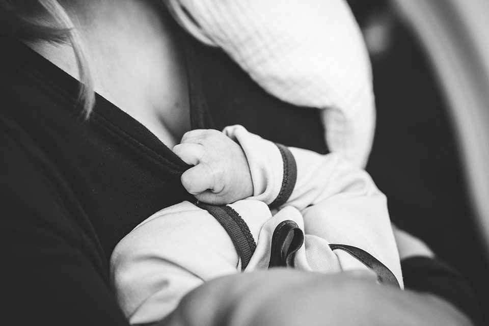 Frau halt Baby im Arm. Schwarz-Weiß-Bild