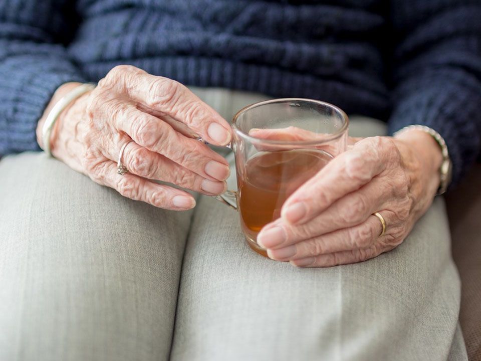 Ältere Person, die Teetasse hält